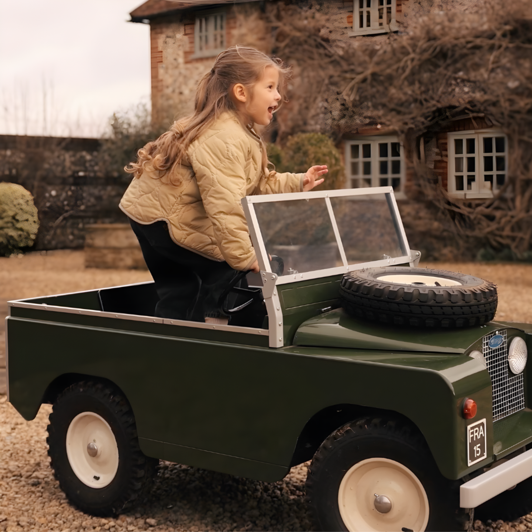 Girl playing in a miniature green car outdoors with a house in the background, wearing NELBEE Quilted Jacket and Jeans